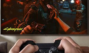 Hænder, der holder joystick og gamer på TV