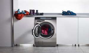 Asko Pro vaskemaskine og bordplade med børnetøj på