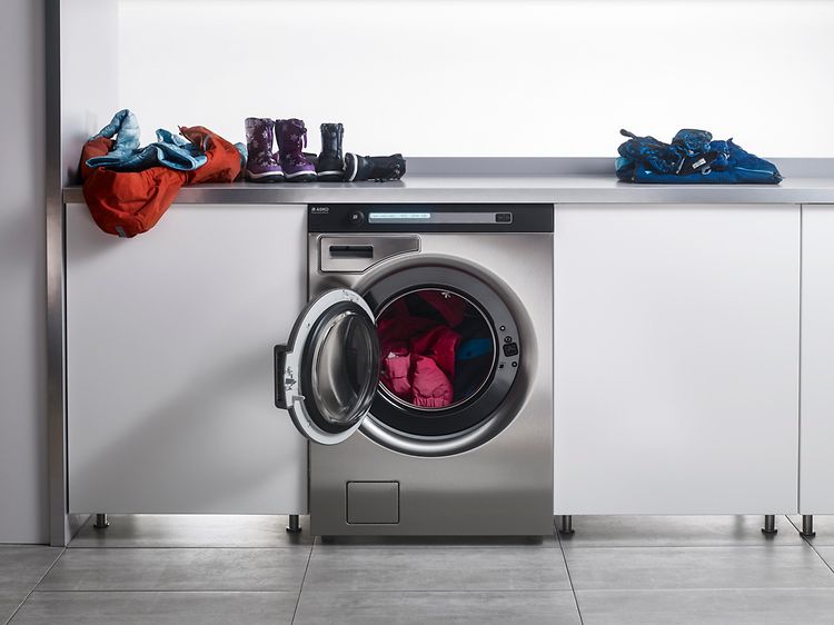 Asko Pro vaskemaskine og bordplade med børnetøj på