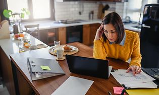 Kvinde arbejder på sin laptop derhjemme