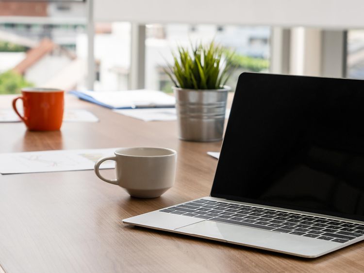 Åben laptop på bord i mødelokale