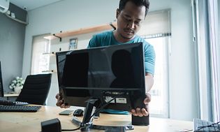 Teknikker installerer computerskærm på et kontor