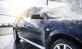Højtryksrenser vasker en sort bil