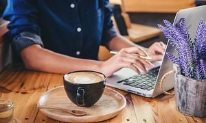 Kvinde sidder på café og arbejder på sin computer