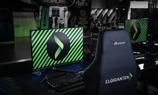Skærm og gamingstol med Elgiganten logo