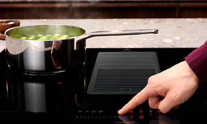 En finger som trykker på en Electrolux ComboHob