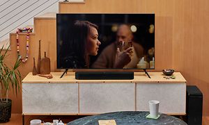 Sonos Beam Gen 2 soundbar og tv med kvinde på skærmen