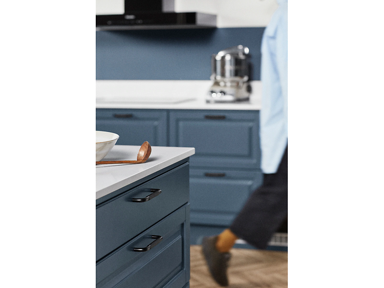 Kitchen in blue and woman in the background