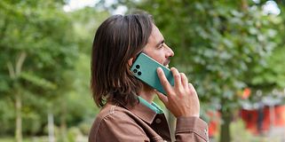 Fairphone 4 i hånden på en mand