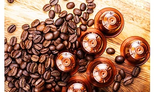 Kaffekapsler og kaffebønner på et bord