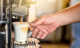 En hånd, der holder en kop kaffe
