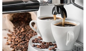 To kopper espresso med kaffebønner omkring