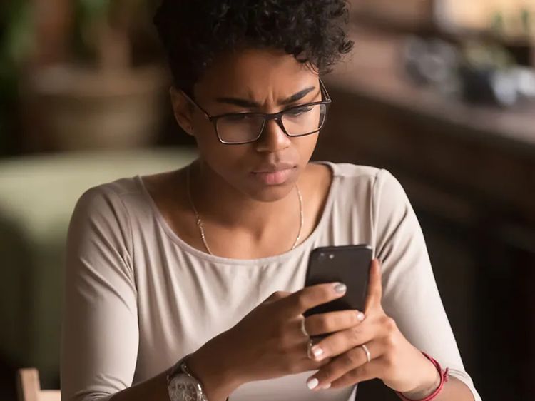 Kvinde holder en smartphone, som hun kigger på