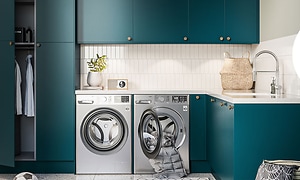 Et blåt bryggers med vaskemaskine og tørretumbler og dansk tekst