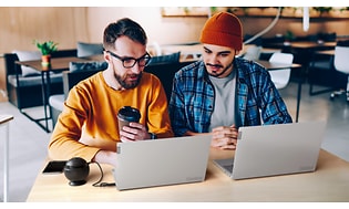 To mænd sidder på café og arbejder på Lenovo Thinkbooks