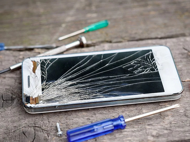 Ødelagt telefon med farverige skruetrækker ved siden af
