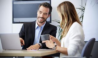 Kundeservice - B2B - Mand og kvinde, der taler forretning på kontoret