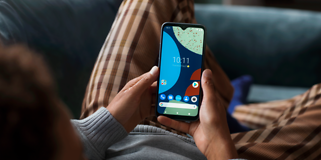 Fairphone 4 i hånden på en person, der ligger ned