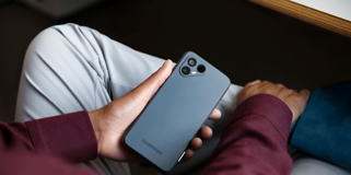 Fairphone 4 i hånden på en person, der sidder indenfor