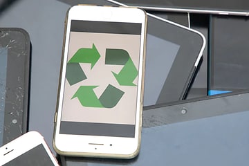 En hvid iPhone med en skærm, der viser et grønt genbrugslogo
