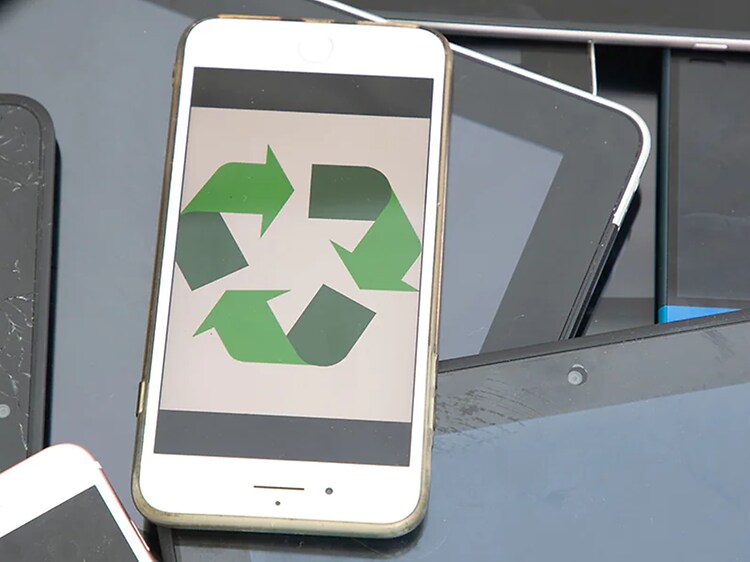 En hvid iPhone med en skærm, der viser et grønt genbrugslogo