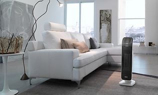 Ceramic De'Longhi radiator i en moderne stue med hvide møbler