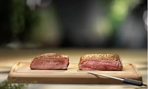 Kød på en træplade ved siden af et digitalt termostat