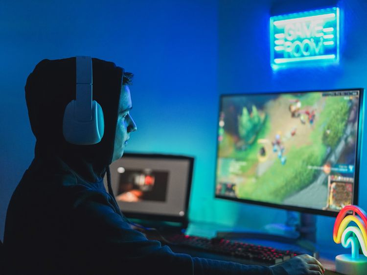 En YouTube gamer med hovedtelefoner foran to skærme