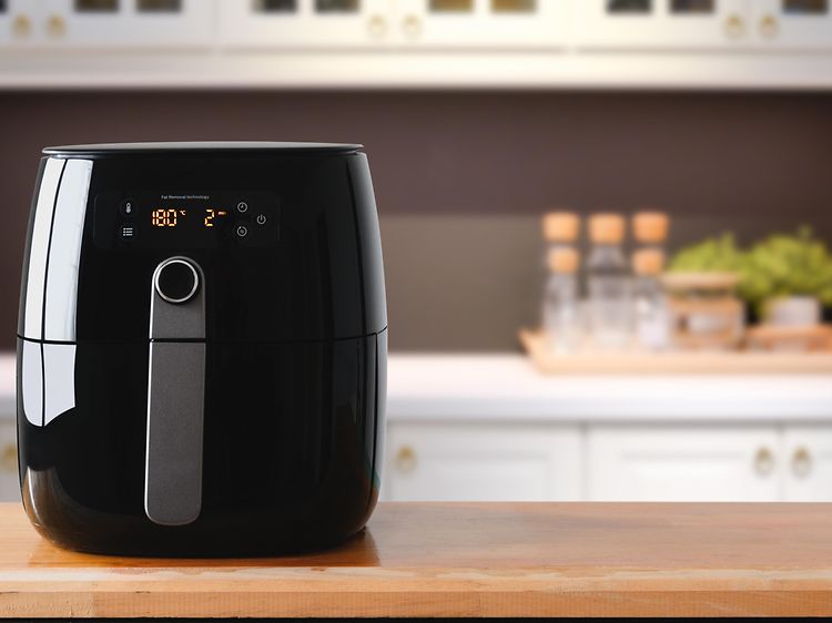 En sort airfryer på et køkkenbord