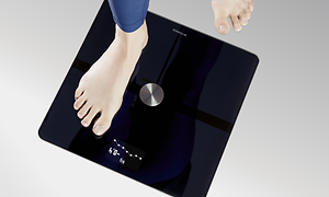 Withings - En kvinde, der står på en Withings smart-vægt