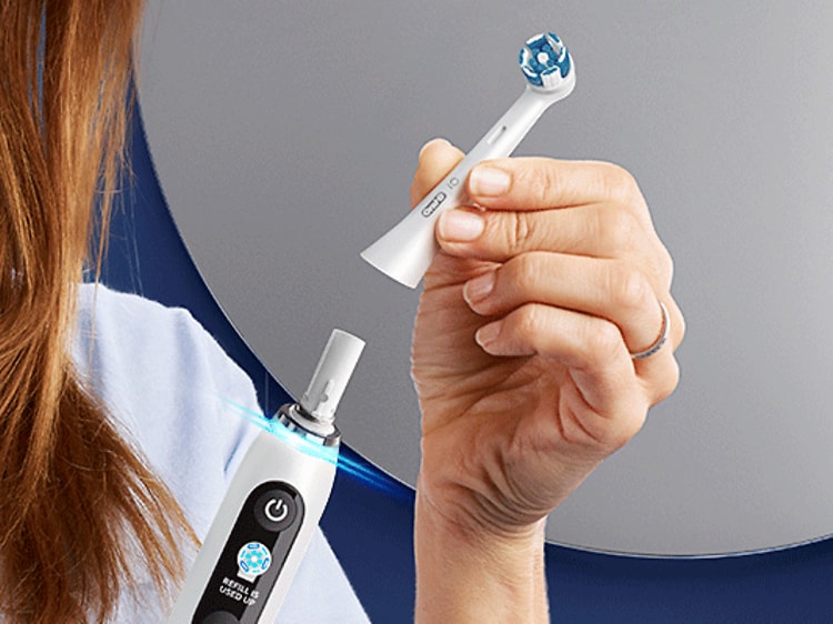 Kvinde skifter børstehoved på en elektrisk tandbørste fra Oral-B 