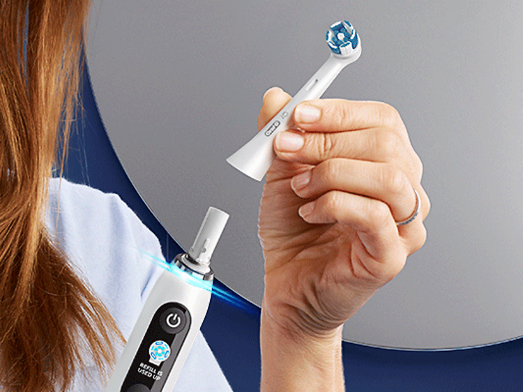 Kvinde skifter børstehoved på en elektrisk tandbørste fra Oral-B
