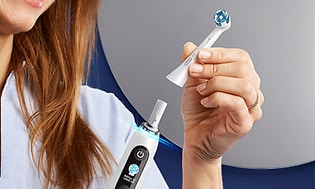 Kvinde skifter børstehoved på en elektrisk tandbørste fra Oral-B