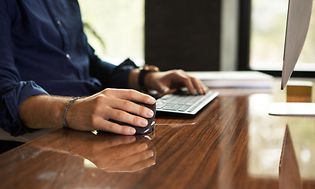 Mand bruger Contour Unimouse, imens han arbejder foran en computer