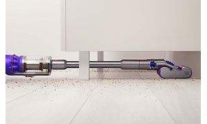 Dyson Omni-Glide går under nogle møbler for at vise, hvor let og kompakt støvsugeren er