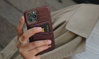 IDEAL OF SWEDEN telefoncover med pung på smartphone holdt afslappet af kvinde udenfor