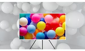 Samsung TV'et The Frame på stativ The Frame med farverige balloner på skærmen