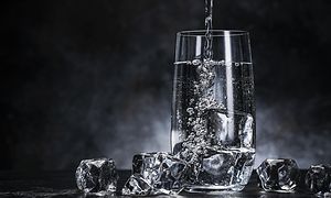Et glas fyldt med vand og isterninger