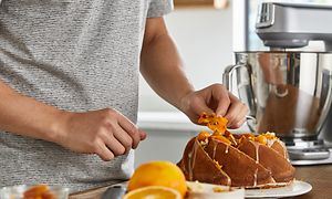 Mand dekorerer kage med Titanium Chef Baker XL i baggrunden