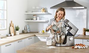SDA - Kenwood - Kvinde står i køkken og bager med Titanium Chef XL