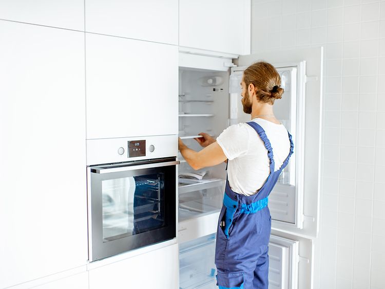 Mand installerer et integreret køleskab