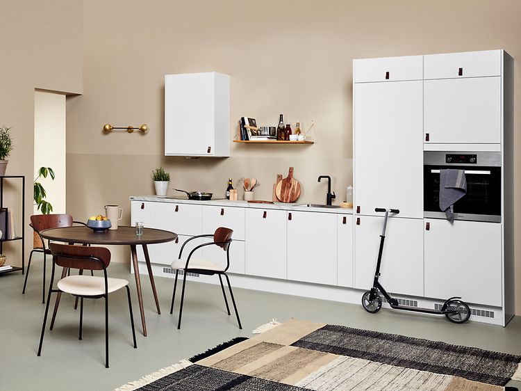 Hvidt EPOQ Core køkken i en åben køkkenløsning med sofa og spisebord