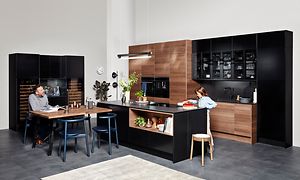 Sort EPOQ Edge-køkken i åbent køkkenløsning med et spisebord og en køkkenø