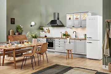 Hvidt EPOQ Heritage køkken i åben køkkenløsning med spisebord, emhætte og køleskab