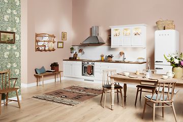 Hvidt EPOQ Heritage køkken i en åben køkkenløsning med spisebord, emhætte og køleskab