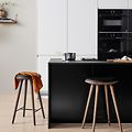 Hvidt EPOQ Integra køkken i en åben køkkenløsning med barstole og sort køkkenø