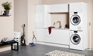 Hvidt EPOQ Integra vaskerum i en åben bryggersløsning med vaskemaskine og tørretumbler