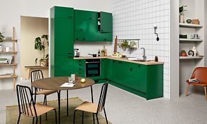 Grønt EPOQ Trend køkken i en åbent køkkenløsning med integreret ovn, træbordplade og et spisebord