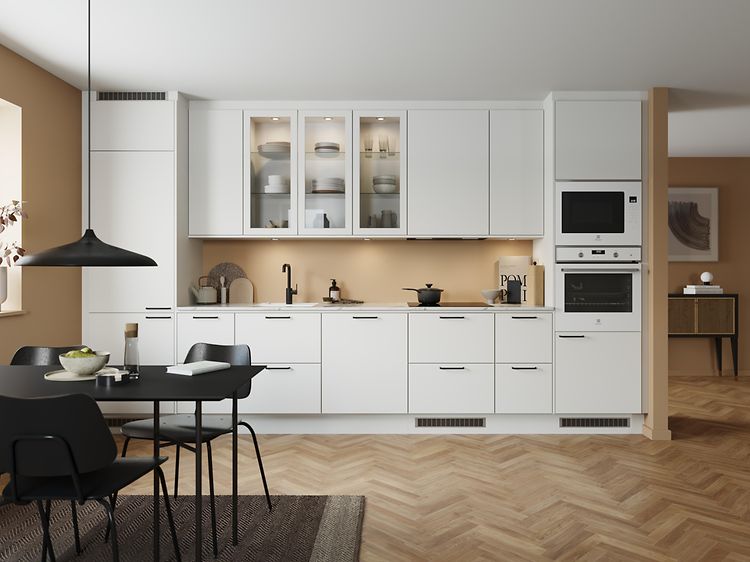Klassisk hvidt EPOQ Trend-køkken i en åben køkkenløsning med integreret ovn, glasskab og spisebord