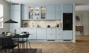 Blue Mist EPOQ Trend-køkken i en åben køkkenløsning med integreret ovn, glasskab og spisebord